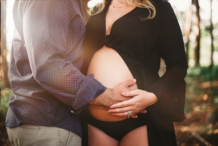 Hermosa foto de maternidad de una mujer embarazada posando con su pareja