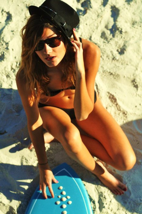 Una mujer posa en una playa para la fotografía de modelos de moda