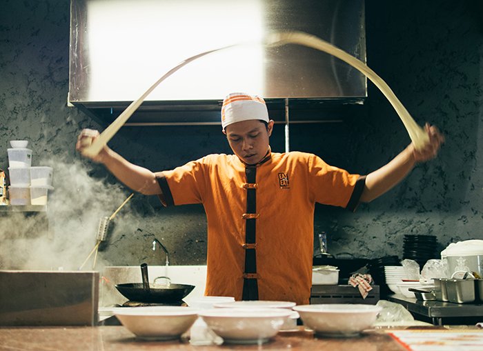 Foto de desenfoque de movimiento de un cocinero asiático