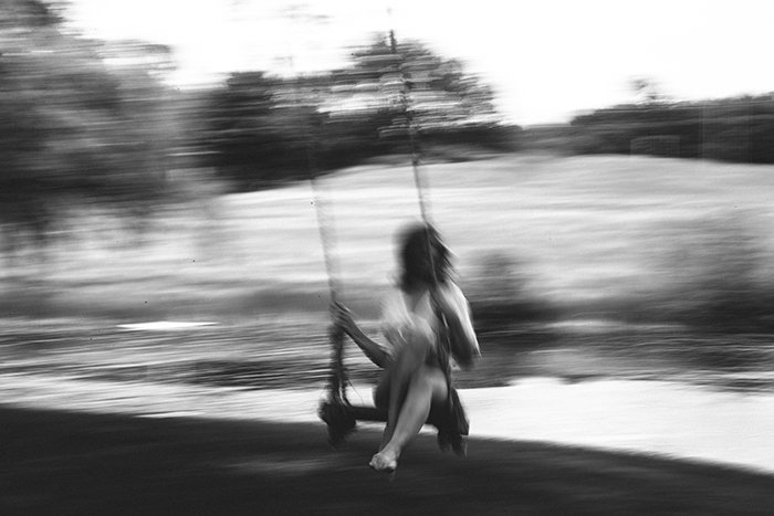 Foto de desenfoque de movimiento de una mujer en un columpio