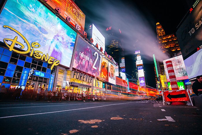 Una escena callejera nocturna llena de luces de neón de los frentes de las tiendas: consejos de fotografía de neón