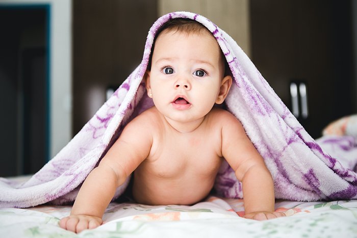 Lindo bebé recién nacido con una manta en la cabeza