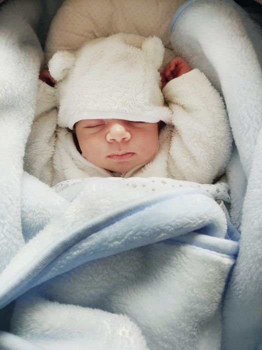 foto de un recién nacido con un lindo sombrero con orejas de oso