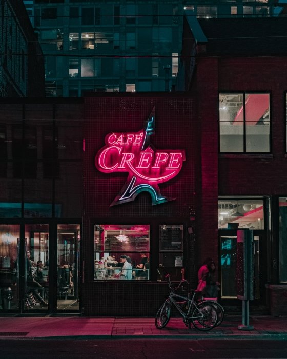 Letrero de neón 'cafe crepe' en la noche