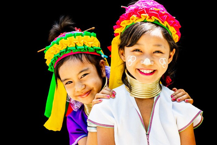 Foto de dos niñas Kayan disfrutando de su retrato en un estudio de fotografía al aire libre en su pueblo en el norte de Tailandia.