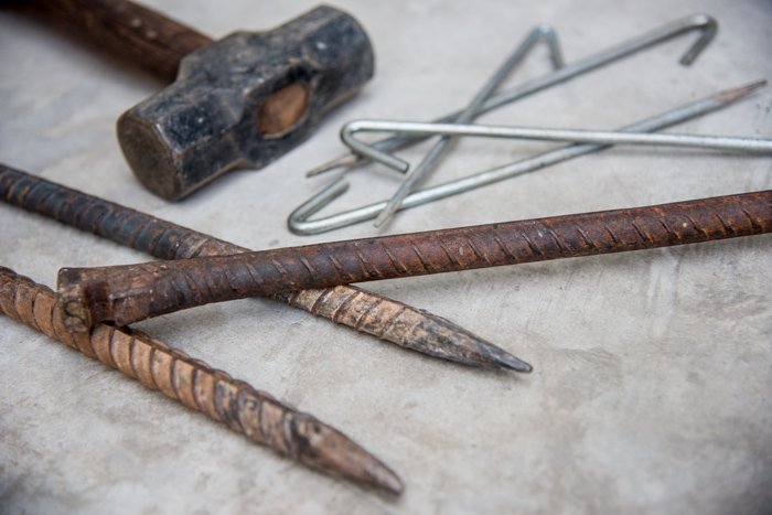 Foto de los postes y clavijas de conexión a tierra necesarios para montar un estudio de fotografía de retratos al aire libre con luz natural.