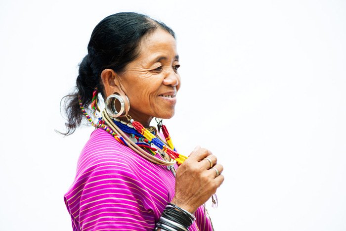 Una foto de estudio de fotografía de retrato al aire libre de una mujer en rosa sobre un fondo blanco.