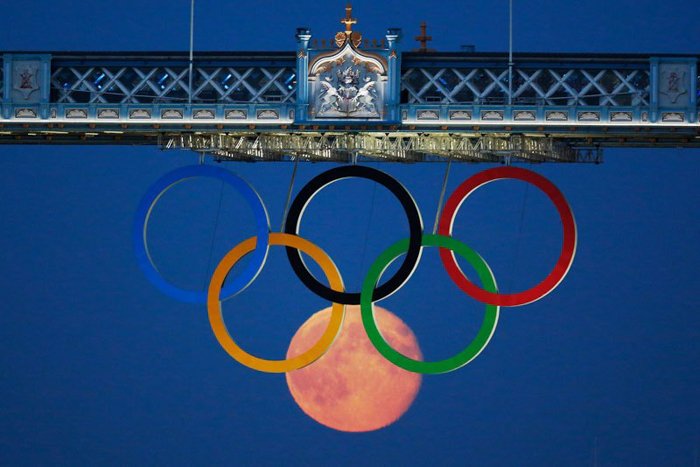 Foto de los anillos olímpicos y la luna debajo de ellos.