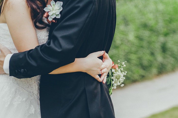 Un primer plano de una pareja de recién casados ​​abrazándose