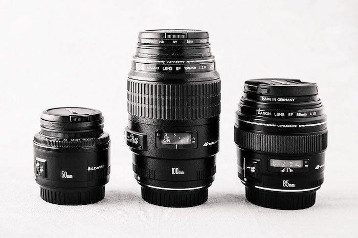 Tres lentes de fotografía diferentes sobre fondo blanco - equipo de negocios de fotografía