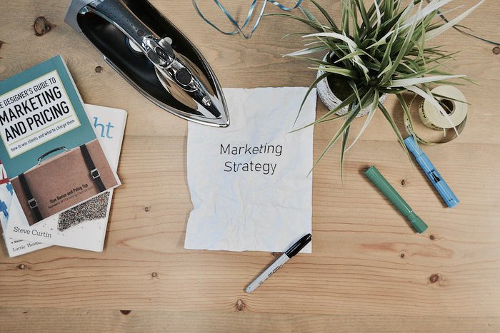 flatlay de un plan de marketing comercial de fotografía, papelería y plantas