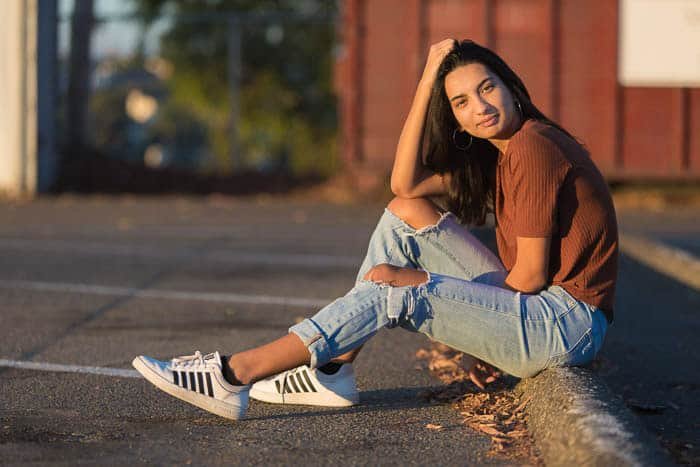 Retrato casual de una niña sentada en una acera
