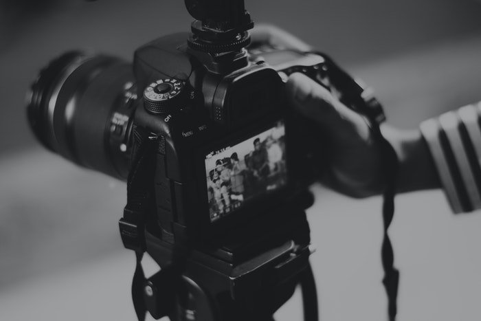 Una persona tomando una foto con una réflex digital grande