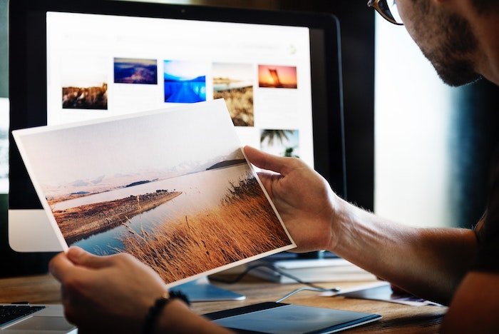 un fotógrafo que edita imágenes de paisajes en una oficina en casa