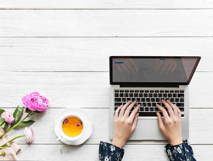 Fotografía cenital de una persona haciendo un plan de marketing fotográfico en una computadora portátil