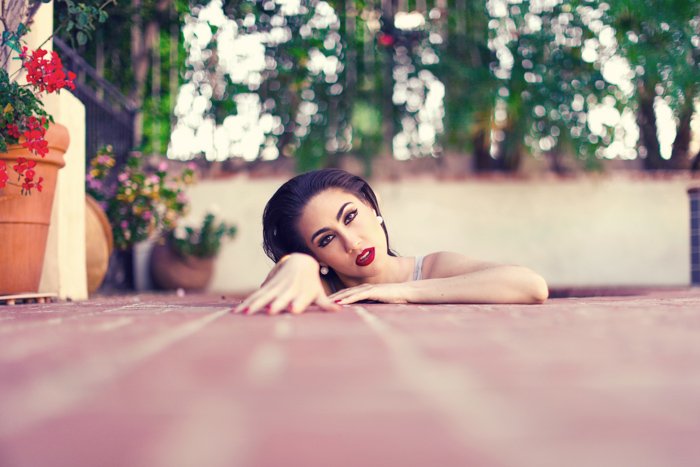 Una foto de retrato creativa de una modelo femenina que surge de tablas de piso rosas