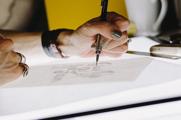 Un primer plano de las manos de un diseñador dibujando manualmente