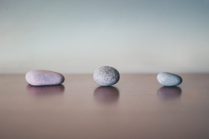 tres piedras grises en la superficie de madera