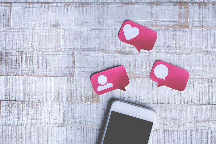 Un teléfono inteligente con papel rosa para compartir en redes sociales y le gustan los íconos encima
