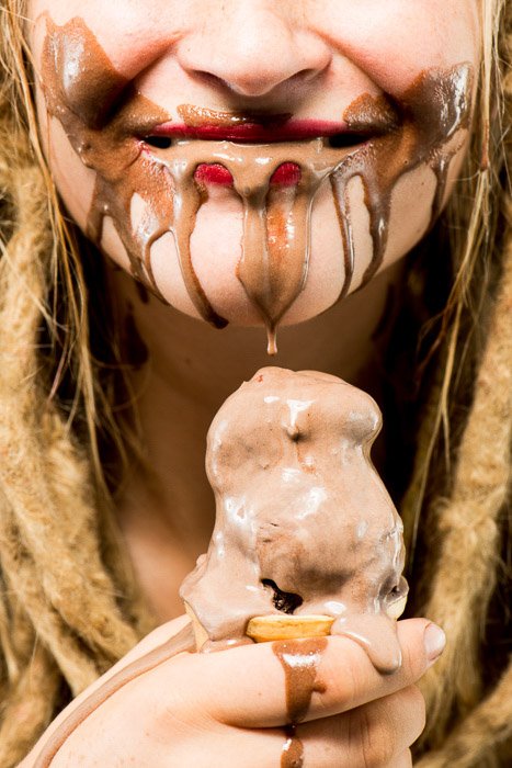 Un retrato de primer plano de una modelo femenina comiendo helado de chocolate con iluminación softbox