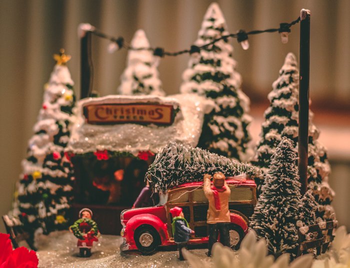 Fotografía de stock con temática navideña de personas en miniatura y árboles de Navidad
