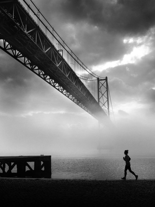 imagen en blanco y negro de un corredor con el brumoso Golden Gate al fondo