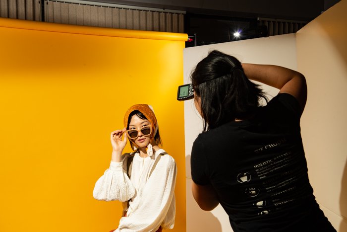 Una fotógrafa tomando fotos de una modelo en un estudio.