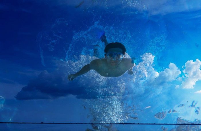 Un hombre nadando superpuesto con una foto de nubes: cómo usar la superposición
