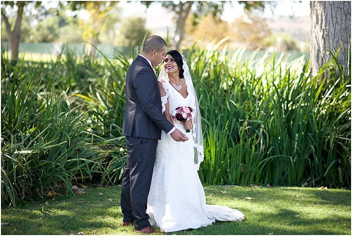 Foto de boda de destino de la pareja de recién casados posando al aire libre