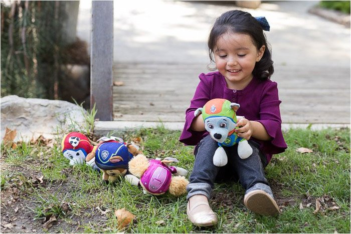 retrato de estilo de vida de una niña agachada en la hierba