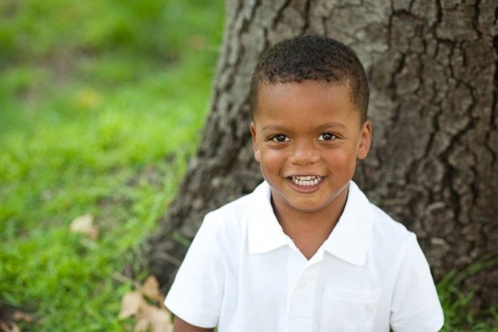 retrato de estilo de vida de una niña agachada en la hierba