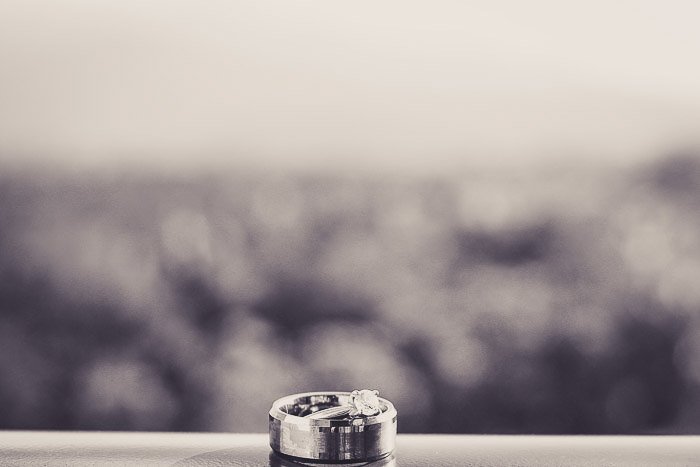 Una foto en blanco y negro de un anillo de bodas en el alféizar de una ventana.  Equipo de fotografía de bodas