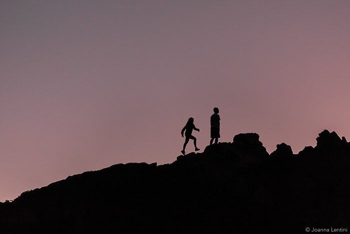 Las siluetas de dos fotógrafos caminando por un paisaje con poca luz: la mejor ropa de vida silvestre