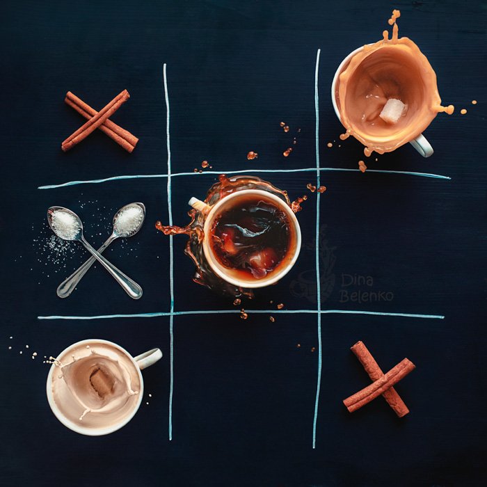 Una fotografía de café creativa aérea del juego tic tac toe creado con tazas de café, palitos de canela y cucharas