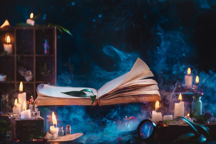 Un espeluznante bodegón fotográfico de Halloween con un libro de hechizos, velas y otros accesorios fotográficos
