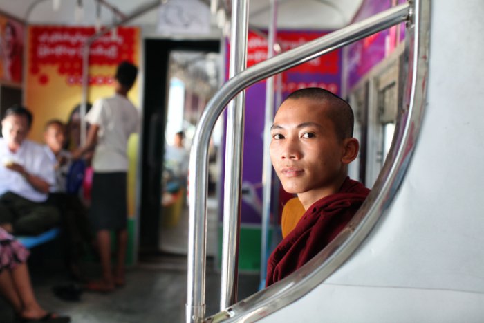 Retrato de un monje budista sentado en el interior de un tren