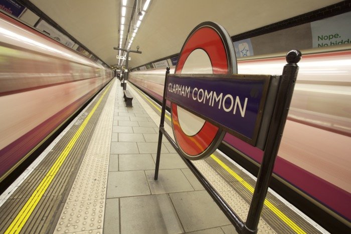 El cartel del metro de Londres entre dos trenes en movimiento