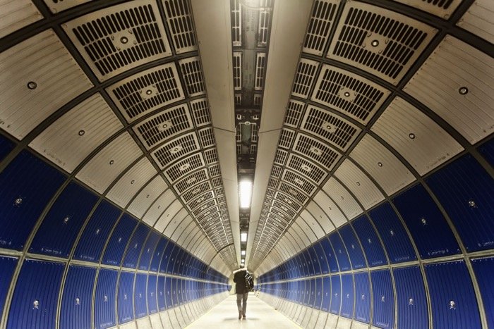 Un hombre que camina a través de un túnel en la línea jubileo del metro de Londres