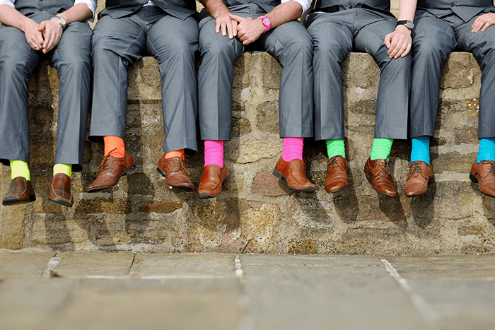 idea de imagen de padrinos de boda: debajo de la cintura de un grupo de padrinos de boda con calcetines coloridos