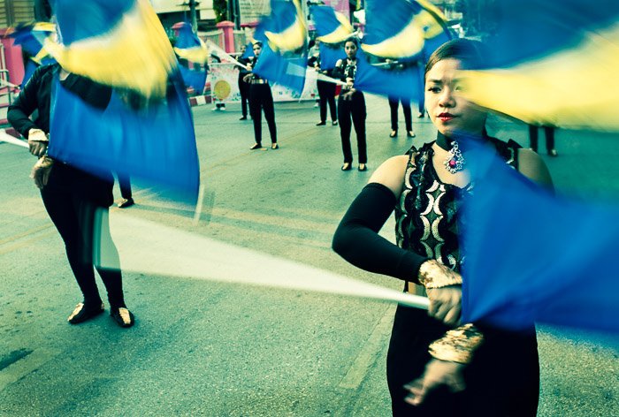 Los jóvenes actúan con banderas en la calle como parte del desfile anual de flores en Chiang Mai, Tailandia.  Narración visual en fotografía