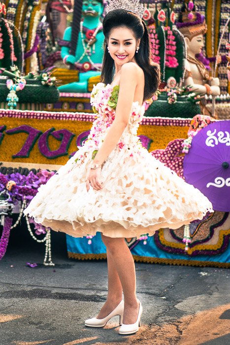 Una mujer joven posando para un retrato callejero, su vestido cubierto de flores reales.  consejos narrativos de fotografía