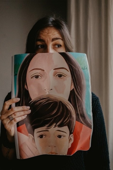 un autorretrato de una mujer sosteniendo una foto de otra mujer y un niño