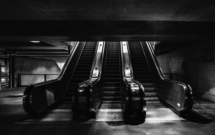 Fotografía en blanco y negro de escaleras mecánicas