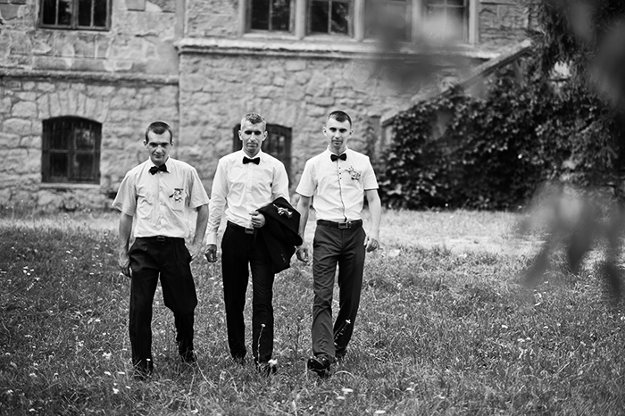 fotos en blanco y negro de tres padrinos de boda caminando hacia la boda