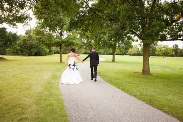 Una novia y un novio posando al aire libre alejándose de la cámara