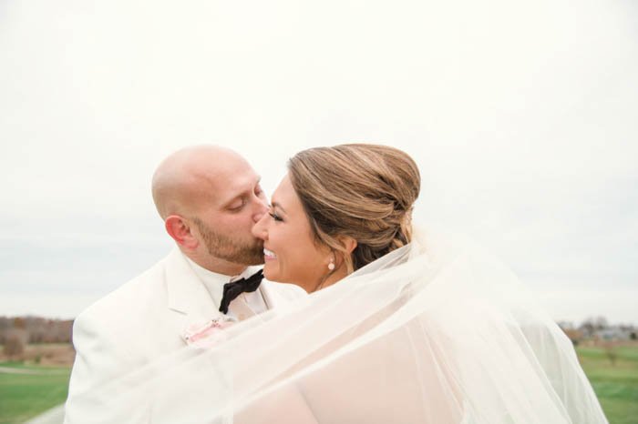 Retrato de boda de la pareja posando al aire libre con el velo