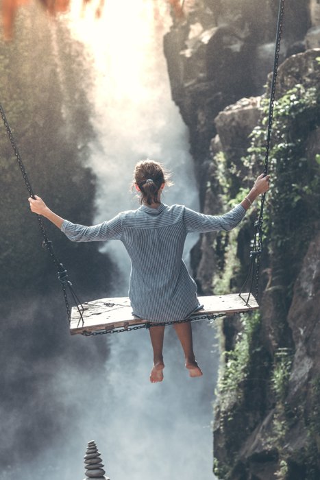 una imagen de una mujer balanceándose sobre un barranco