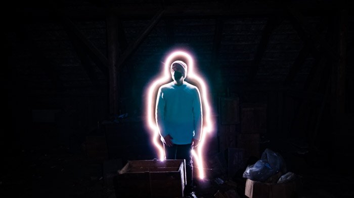 Retrato creativo de un hombre iluminado con un palo de luz.