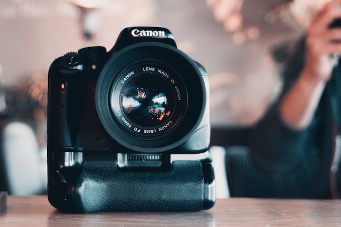 primer plano de una cámara Canon desde el frente, sobre una mesa