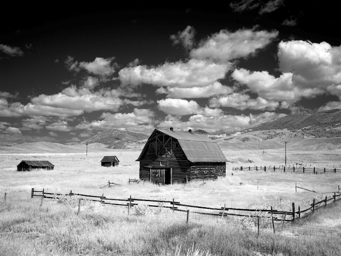 foto en blanco y negro de un antiguo granero de madera en un campo